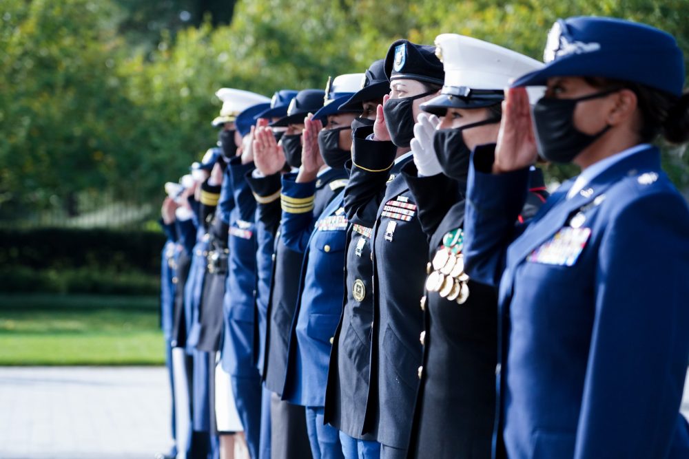 Servicewomen in uniform saluting